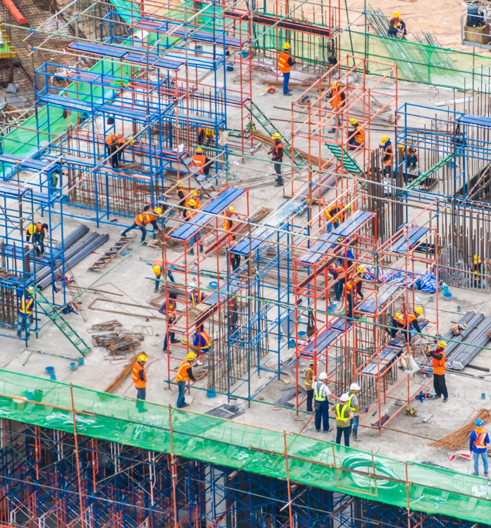 Building construction with lots of workers and piping